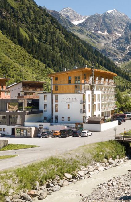 Riverside hotel with a mountain backdrop of snow-capped peaks