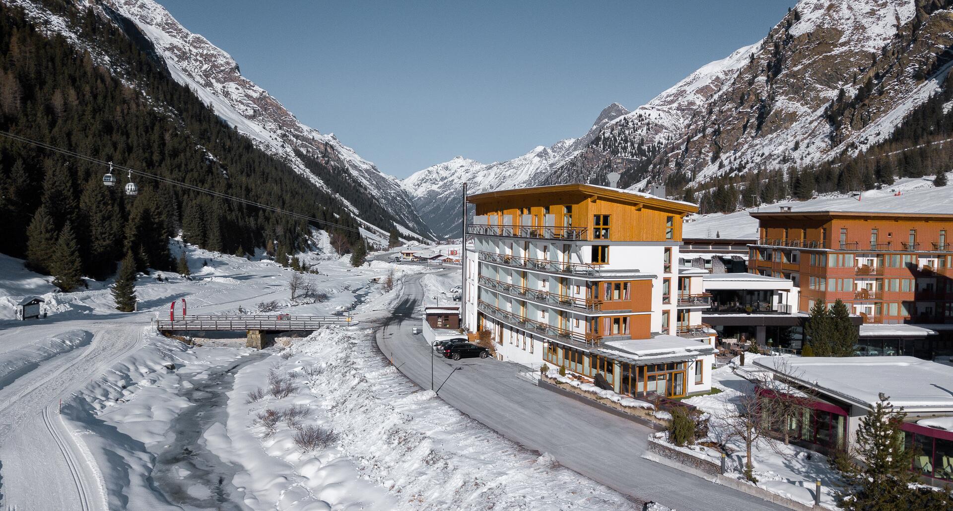 DAS VIER Tyrol in winter in front of snow-capped mountains, drone perspective