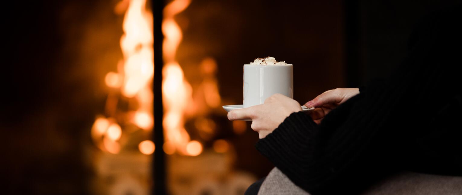 enjoy hot chocolate by the fireplace