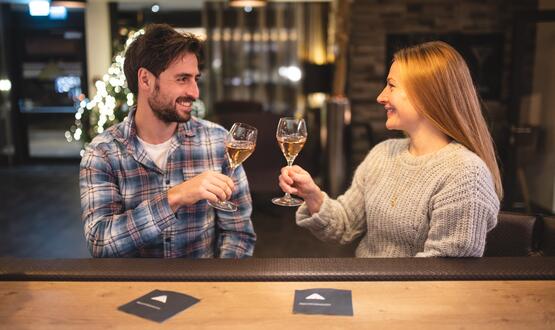 Couple toasting each other with champagne glasses at a bar