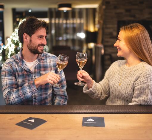 Paar prostet sich mit Sektgläsern an einer Bar zu