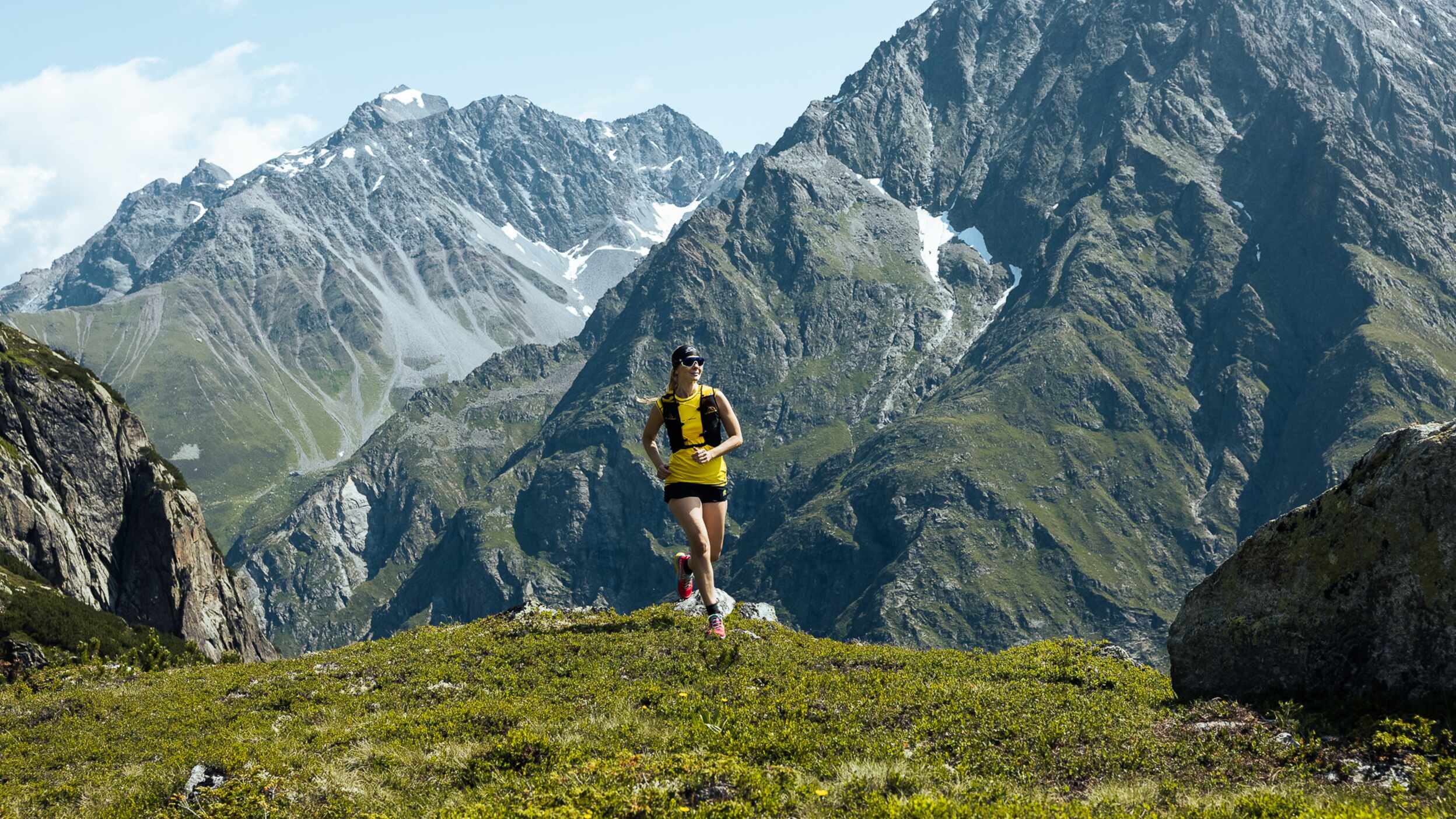 Trailrunnerin vor Bergpanorama