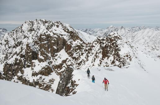 Vier Personen beim Skitourengehen in verschneiter Berglandschaft im Pitztal